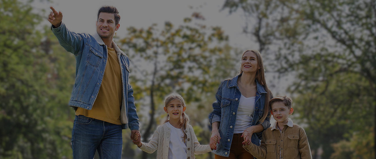 A family enjoying a walk in a green park under a clear sky, reflecting harmony and togetherness.